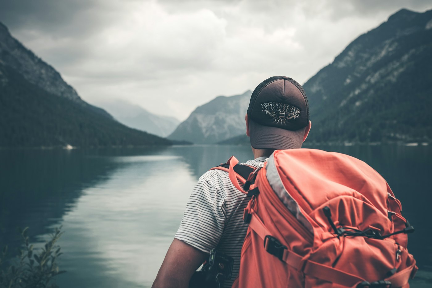 Traveler looking out over a misty mountain lake